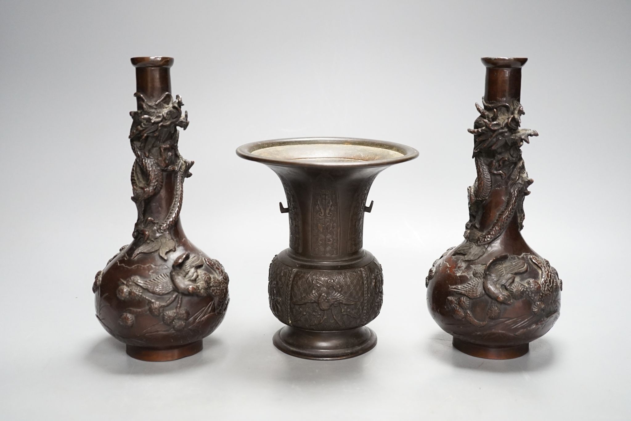 A pair of Japanese Meiji period bronze ‘dragon’ bottle vases and another, 21cm